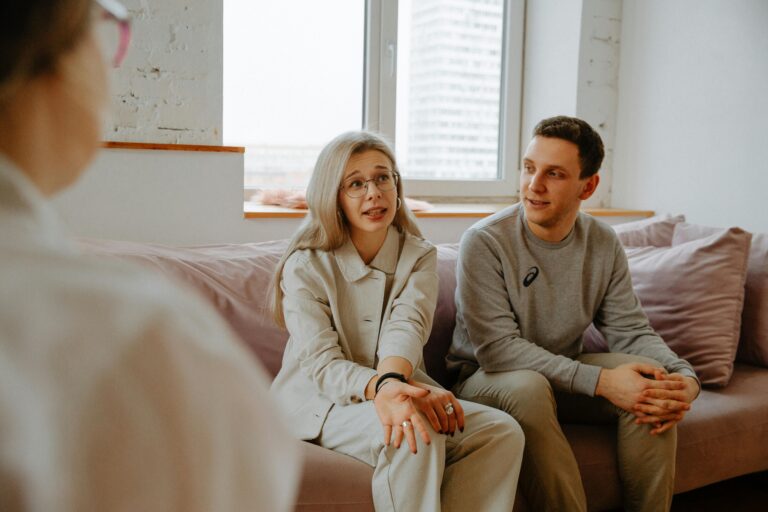 Couples Counselling. A couple and therapist engaged in a discussion during a therapy session indoors.